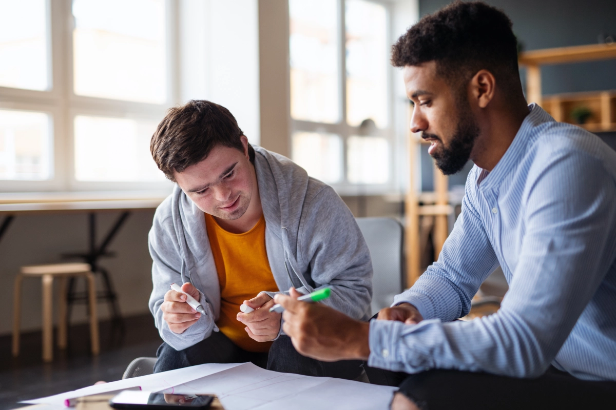Two men collaborating with notes and pens.