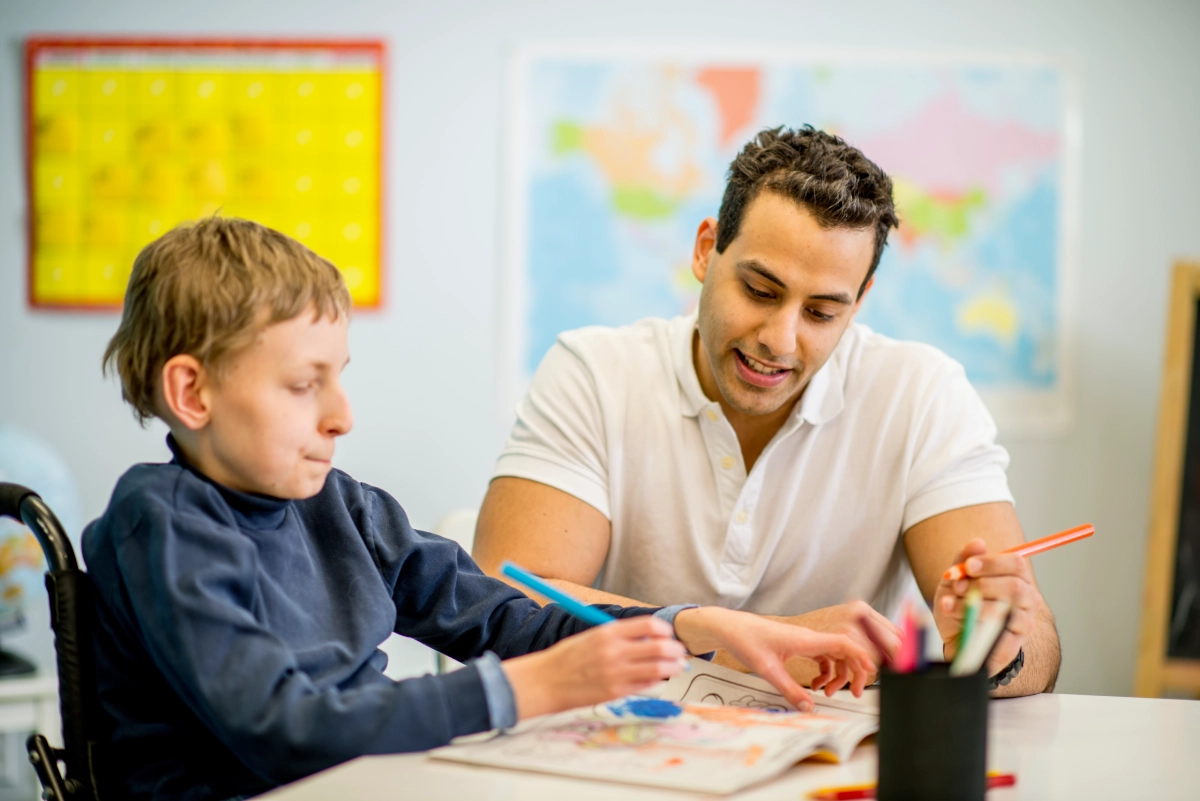 Teacher helping student with drawing activity.